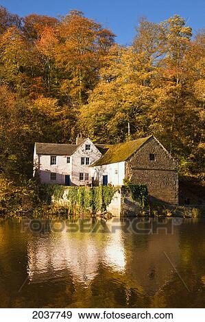 Stock Photo - A House Along The River Reflected In The Water In Autumn; Durham England. Fotosearch