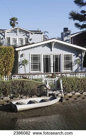 A house along the water with a canoe on the rocky shore; California, United States of America View Large Photo Image Stock Image - A house along the water with a canoe on the rocky shore; California, United States of America. Fotosearch