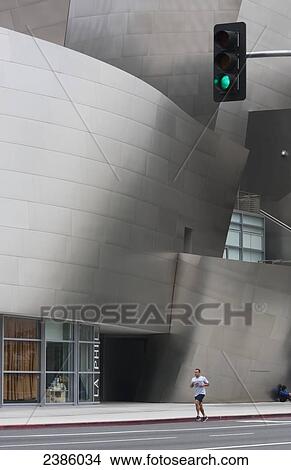 A jogger runs on a road beside a modern building; California, United States of America View Large Photo Image Picture - A jogger runs on a road beside a modern building; California, United States of America. Fotosearch