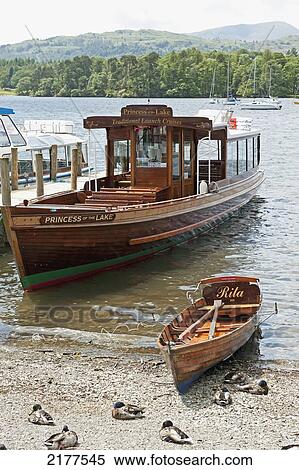 Stock Photography - A Large And Small Wooden Boat Beside Each Other In The Shallow Water Along The Beach; England. Fotosearch