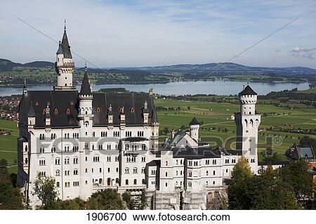 Stock Image - A Large Bavarian Castle With Fields, Lake And Village In The Background; Fussen, Germany. Fotosearch