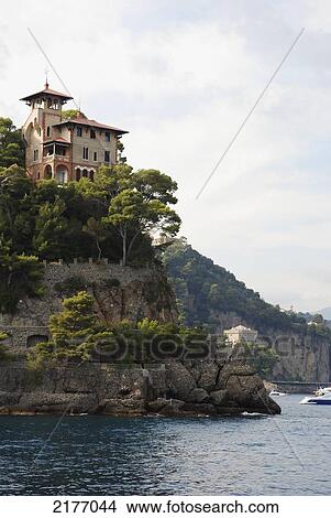 Picture - A Large House On A Cliff At The Water's Edge; Italy. Fotosearch