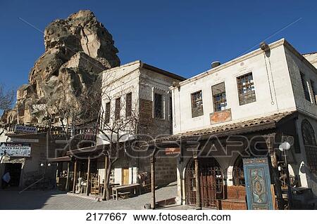 Stock Photo - A Large Rock Formation (Castle Of Ortahisar) Against A Blue Sky In An Urban Area; Ortahisar Nevsehir Turkey. Fotosearch