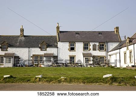 Stock Photo - A Large White Building With Picnic Tables Outside. Fotosearch