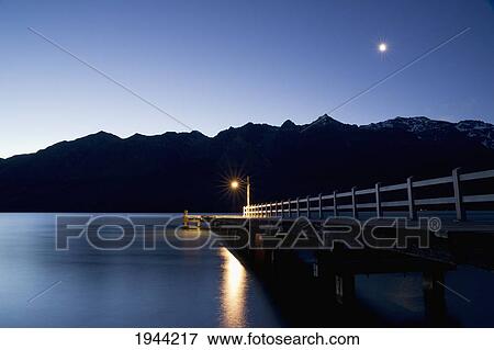 A Light On The End Of A Wooden Dock And A Full Moon In The Sky; Glenorchy South Island New Zealand View Large Photo Image Stock Photo - A Light On The End Of A Wooden Dock And A Full Moon In The Sky; Glenorchy South Island New Zealand. Fotosearch