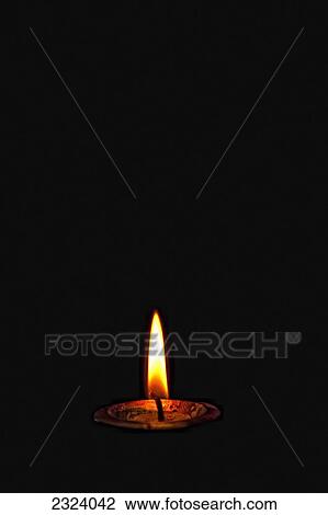 A lit candle in the darkness View Large Photo Image Stock Image - A lit candle in the darkness. Fotosearch