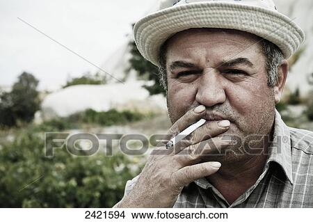 A local farmer smoking a cigarette; Cappadocia, Turkey View Large Photo Image Picture - A local farmer smoking a cigarette; Cappadocia, Turkey. Fotosearch