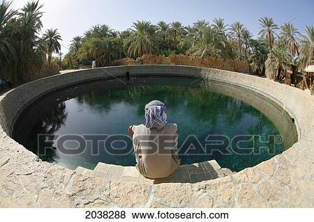 A Local Siwan Man Looks Into Cleopatra's Pool A Natural Fresh Water Spring In Siwa At The Siwa Oasis; Siwa Egypt View Large Photo Image Stock Photo - A Local Siwan Man Looks Into Cleopatra's Pool A Natural Fresh Water Spring In Siwa At The Siwa Oasis; Siwa Egypt. Fotosearch