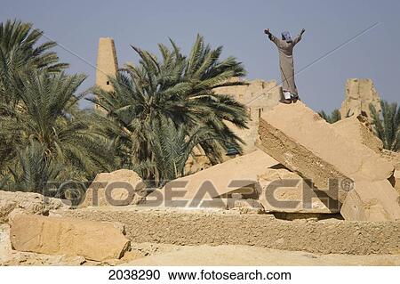Stock Image - A Local Siwan Man Raises His Arms Into The Air In Siwa At The Siwa Oasis; Siwa Egypt. Fotosearch