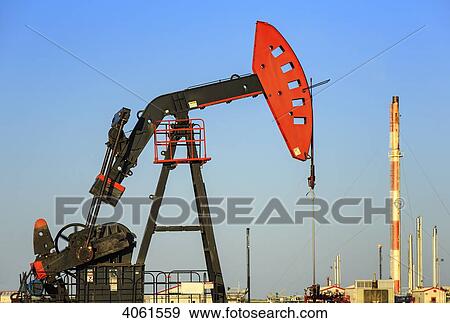 Stock Photo - A made in China oil pump jack and a natural gas plant at Bakken Oil Field near Estevan; Saskatchewan, Canada. Fotosearch