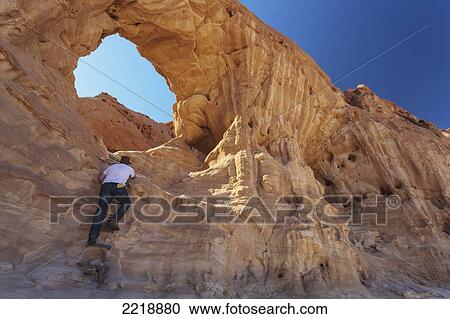 Stock Image - A Man Climbs A Sandstone Rock Formation; Timna Park Arabah Israel. Fotosearch