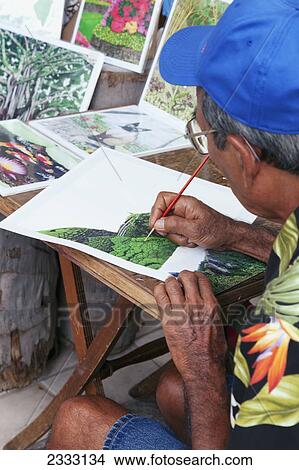 Picture - A man creates Hawaiian themed artwork in an outdoor market; Oahu, Hawaii, United States of America. Fotosearch