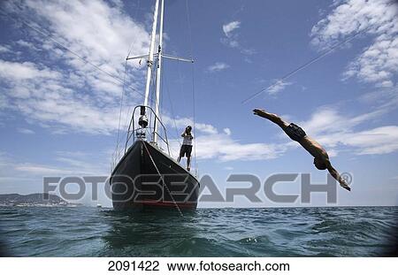 Stock Image - A Man Dives Into The Sea From A Yacht Anchored Off Gibraltar.. Fotosearch