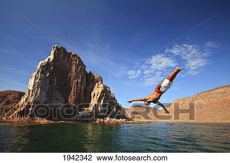 Stock Image - A Man Dives Into The Water Off Espiritu Santos Island Near La Paz; Baja California Mexico. Fotosearch