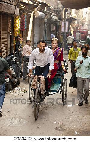 A Man Drives A Cycle Rickshaw Down A Narrow Street With A Woman Passenger; Ludhiana, Punjab, India View Large Photo Image Stock Image - A Man Drives A Cycle Rickshaw Down A Narrow Street With A Woman Passenger; Ludhiana, Punjab, India. Fotosearch
