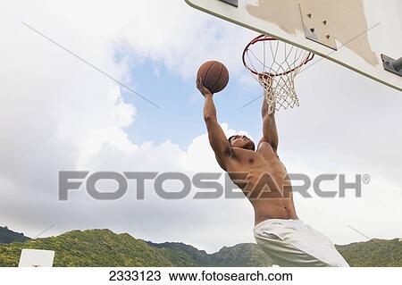 A man dunking a basketball in the hoop; Oahu, Hawaii, United States of America View Large Photo Image Stock Image - A man dunking a basketball in the hoop; Oahu, Hawaii, United States of America. Fotosearch