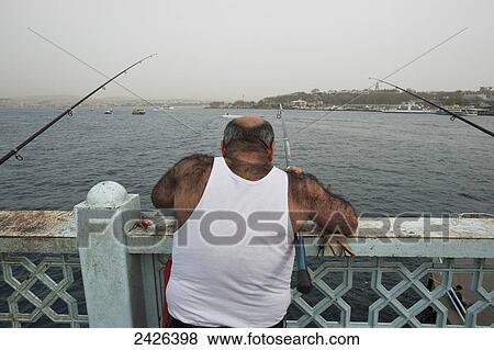 A man fishes off a bridge; Istanbul, Turkey View Large Photo Image Stock Photo - A man fishes off a bridge; Istanbul, Turkey. Fotosearch