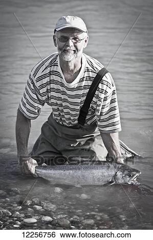 A man kneeling in the river with a fresh caught fish; Hope, British Columbia, Canada View Large Photo Image Stock Photograph - A man kneeling in the river with a fresh caught fish; Hope, British Columbia, Canada. Fotosearch