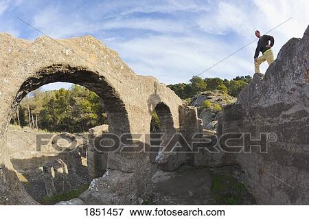 Stock Photo - A Man Looking Over Stone Ruins; Andalusia, Spain. Fotosearch