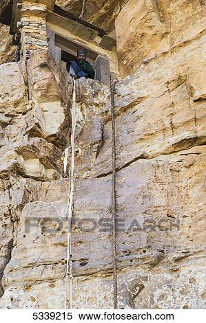 A man looks out the window from a rock-cut cliff; Lalibela, Ethiopia View Large Photo Image Stock Photography - A man looks out the window from a rock-cut cliff; Lalibela, Ethiopia. Fotosearch
