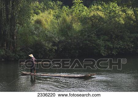 A Man Paddles In The Yulong River; Yangshuo, Guangxi, China View Large Photo Image Stock Image - A Man Paddles In The Yulong River; Yangshuo, Guangxi, China. Fotosearch