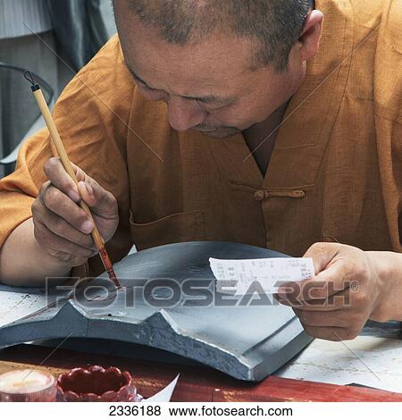 Stock Photo - A Man Painting Characters With A Fine Brush Stroke; Xi'an, Shaanxi, China. Fotosearch