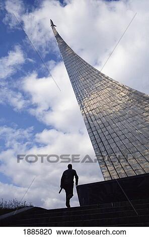 Stock Image - A Man Passes A Monument To Honor Russian Space Exploration. Fotosearch