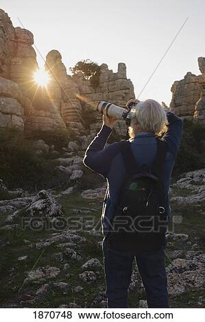 Stock Photo - A Man Photographs Rock Formations; El Torcal De Antequera, Malaga, Andalusia, Spain. Fotosearch