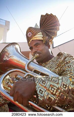 Stock Image - A Man Playing A Brass Instrument; Ludhiana, Punjab, India. Fotosearch
