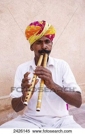 Stock Photography - A man playing a musical instrument at Ranvas Palace; Rajasthan, India. Fotosearch