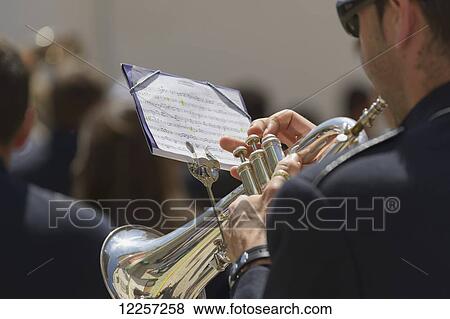 Stock Photo - A man playing a trumpet with music mounted on the instrument, Semana Santa; El Saucejo, Sevilla, Spain. Fotosearch