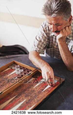 Stock Photo - A man playing backgammon; Urgup, Cappadocia, Turkey. Fotosearch