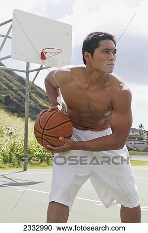 Stock Image - A man playing basketball; Oahu, Hawaii, United States of America. Fotosearch