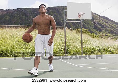 Stock Image - A man playing basketball; Oahu, Hawaii, United States of America. Fotosearch