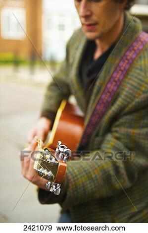 A man plays his acoustic guitar on Portobello Road; London, England View Large Photo Image Stock Photo - A man plays his acoustic guitar on Portobello Road; London, England. Fotosearch