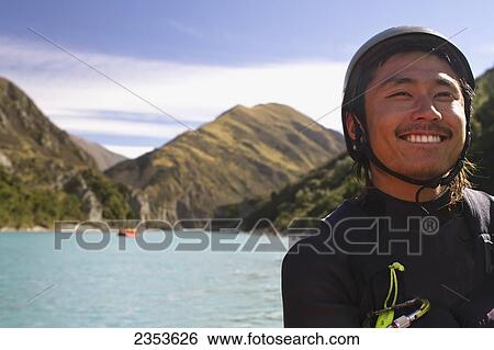 Stock Photograph - A Man Poses As A Group Is Rafting Down The Rangitata Gorge And The Rangitata River; Rangitata, New Zealand. Fotosearch