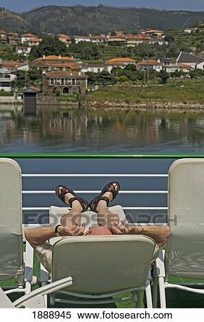 Stock Photography - A Man Relaxing On Deck Aboard A Douro Valley River Cruise. Fotosearch