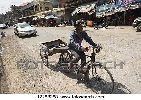 A man riding his bicycle and cart around Old market; Battambang, Cambodia View Large Photo Image Stock Photo - A man riding his bicycle and cart around Old market; Battambang, Cambodia. Fotosearch
