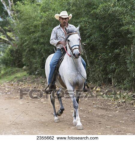 Stock Image - A Man Riding Horseback On A Trail; Zacapa, Guatemala. Fotosearch