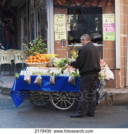 Stock Photography - A Man Sells Nuts And Fruit From A Cart On The Street; Istanbul Turkey. Fotosearch