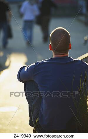 A man sits in the sunshine watching pedestrians; Hamburg, Germany View Large Photo Image Stock Photo - A man sits in the sunshine watching pedestrians; Hamburg, Germany. Fotosearch
