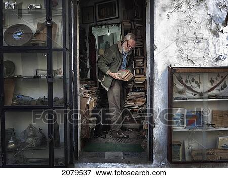 Stock Photo - A Man Sorting Books In A Shop; Tangier Morocco. Fotosearch