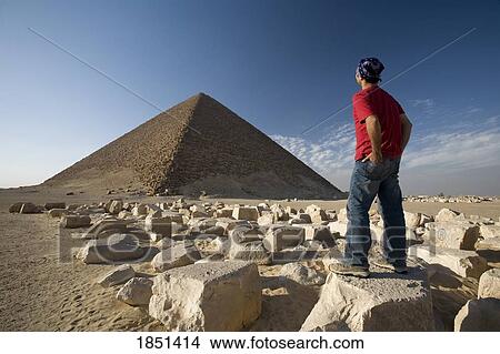 Picture - A Man Standing Near A Pyramid In The Desert; Egypt, Africa. Fotosearch