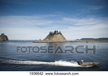Stock Image - A Man Stands In A Motorboat And Drives Through Quileute River; La Push Washington United States Of America. Fotosearch