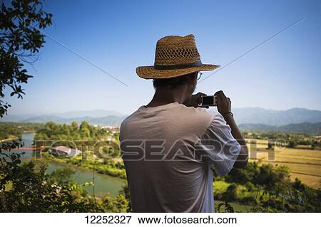 A man views the countryside; Vang Vieng, Laos View Large Photo Image Stock Photo - A man views the countryside; Vang Vieng, Laos. Fotosearch