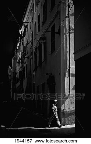 A Man Walks Alone Into An Illuminated Alley At Night; Genoa Liguria Italy View Large Photo Image Stock Photo - A Man Walks Alone Into An Illuminated Alley At Night; Genoa Liguria Italy. Fotosearch