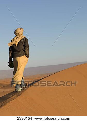 Picture - A Man Walks On The Erg Chegaga Dunes; Souss-Massa-Drass, Morocco. Fotosearch