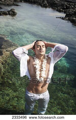 A man wearing a floral lei standing in shallow water; Honolulu, Oahu, Hawaii, United States of America View Large Photo Image Stock Photograph - A man wearing a floral lei standing in shallow water; Honolulu, Oahu, Hawaii, United States of America. Fotosearch