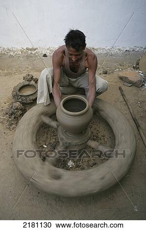 Stock Image - A man working on a pottery wheel, Potters village; Madhya Pradesh, India. Fotosearch