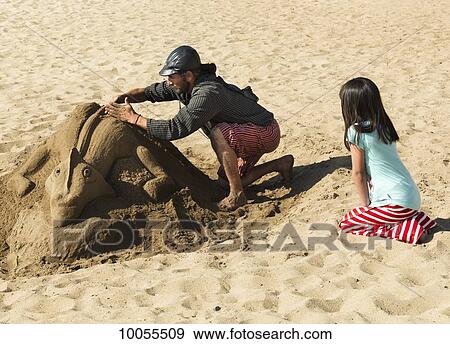 A man works on a sand sculpture while a young girl watches; Vina Del Mar, Valparaiso, Chile View Large Photo Image Stock Photo - A man works on a sand sculpture while a young girl watches; Vina Del Mar, Valparaiso, Chile. Fotosearch